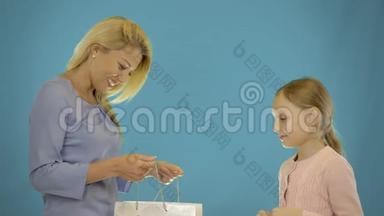 母亲和女儿购物。 妈妈和女儿一起在购物袋里送礼物。 妈妈和女儿送礼物